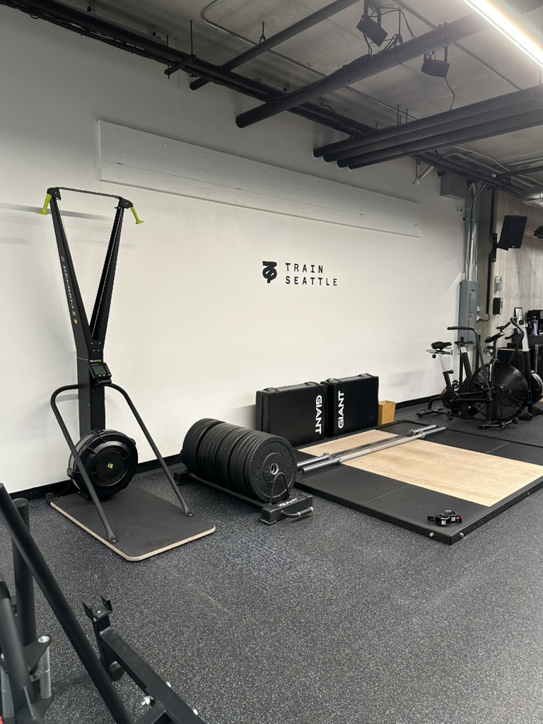Ski trainer, bumper plates and lifting platform beside the TRAIN SEATTLE wall mark in Belltown